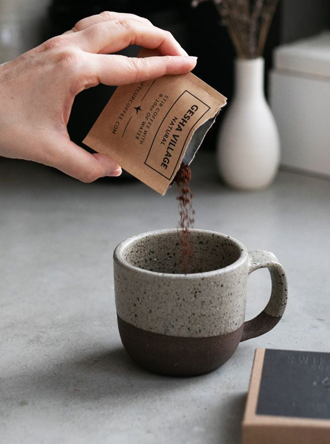 Coffee being poured into a ceramic cup